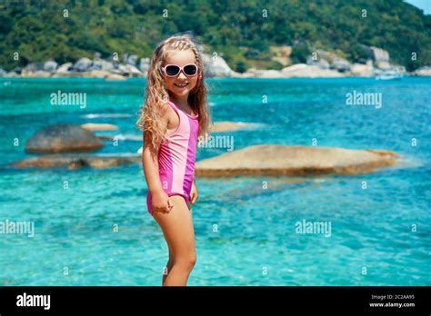 Nettes Kleines Mädchen In Sonnenbrillen Posiert Auf Schönen Tropischen Strand Stockfotografie