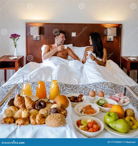 breakfast in bed couple drinking coffee in bed in the morning at an luxury hotel room stock