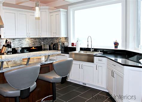 A backsplash can be an excellent focal point, but it can also be used to feature other parts of the kitchen, such as the countertops. High contrast whtie kitchen with black countertops and farmhouse stainless sink. Kylie M interiors