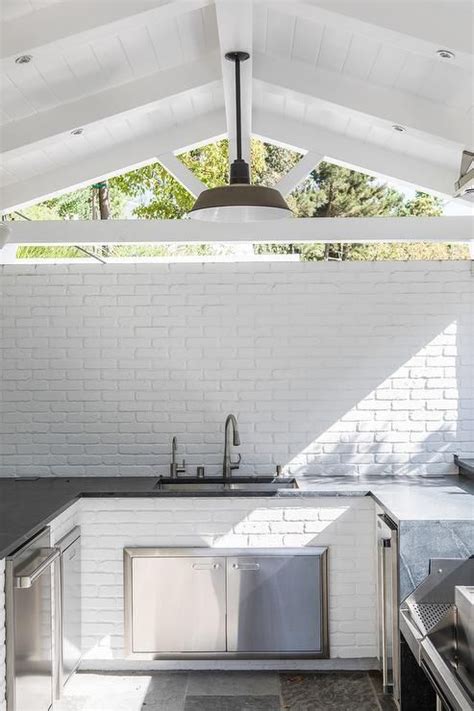 U Shaped Outdoor Kitchen With A Sink Surrounded By White Brick Vaulted