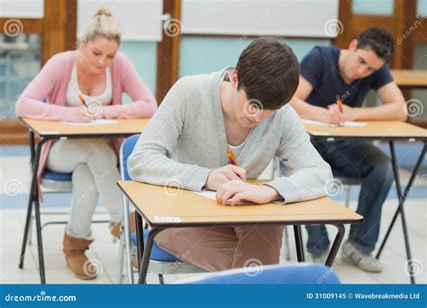 Writing Students At Desks In A Classroom Stock Image Image Of