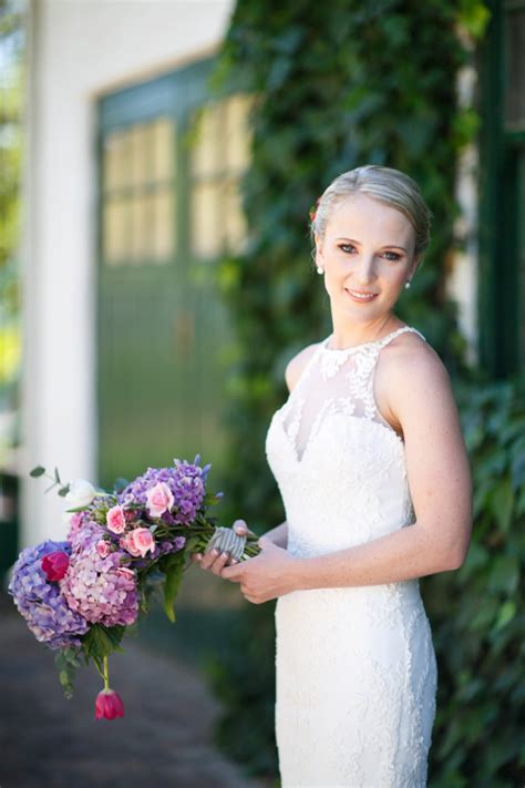 Long reception table decorated with coral, purple and blue flowers {photo: 25 Cascade and Long Bridal Bouquets