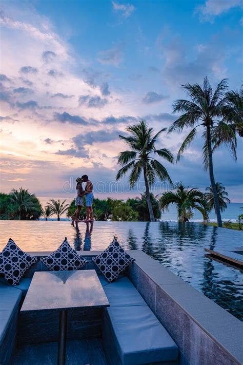 Couple Watching Sunset In Infinity Pool On A Luxury Vacation In Thailand Man And Woman Watching