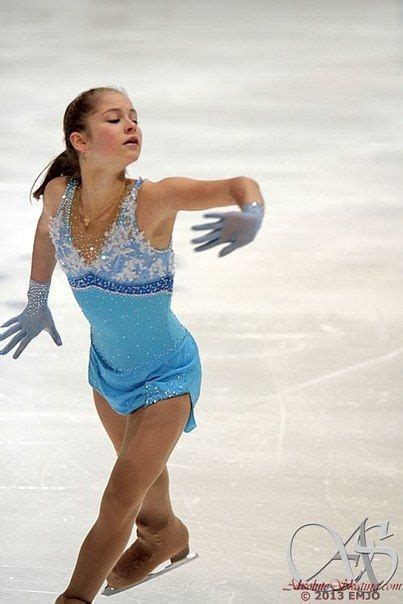 A Woman Skating On An Ice Rink Wearing A Blue Dress And Gloves With Her