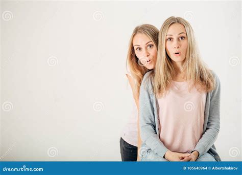 Surprised Girl Looking At Her Sister Twin Over White Background Stock