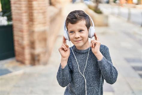 Blond Child Smiling Confident Listening To Music At Street Stock Image