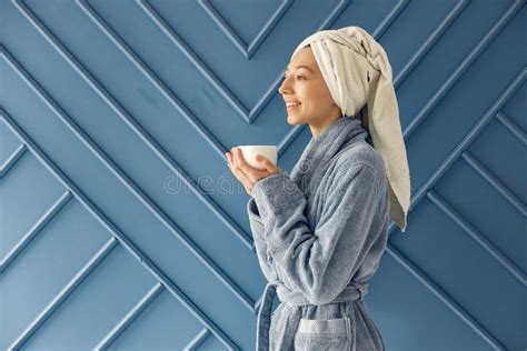 Beautiful Girl Standing In A Studio In A Blue Bathrobe Stock Image