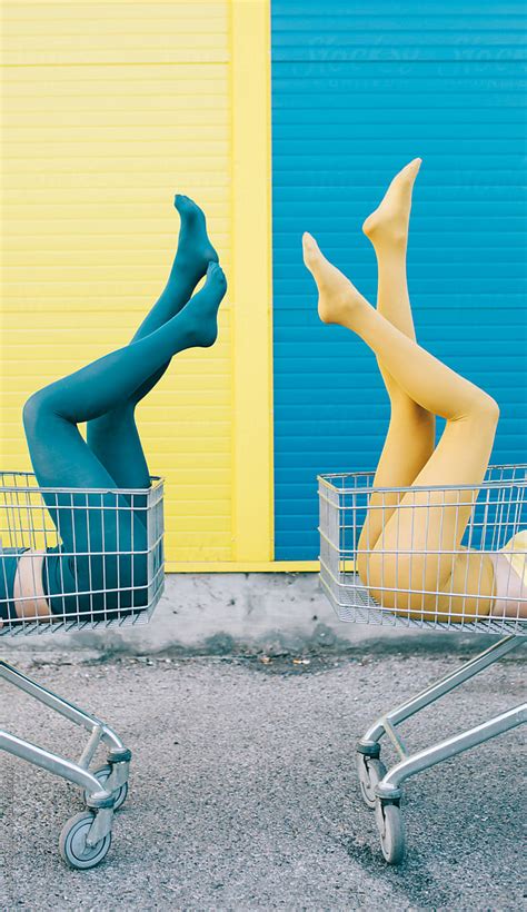 Two Female Friends In Front Of A Blue Yellow Wall By Stocksy