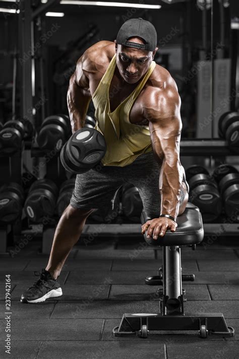 Muscular Man Working Out In Gym Doing Exercises For Back Single Arm Dumbbell Row Stock Photo