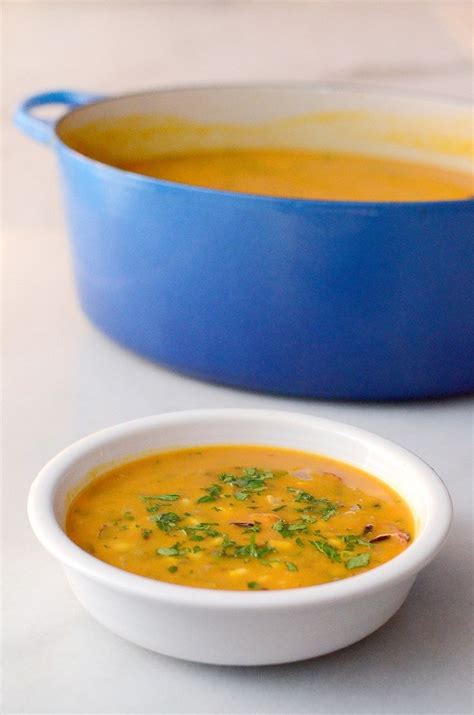 A Bowl Of Soup Next To A Blue Casserole Dish