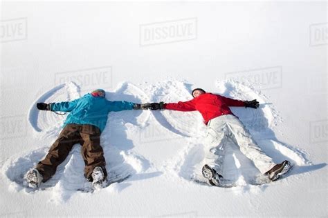 Couple Making Snow Angels Outdoors Stock Photo Dissolve