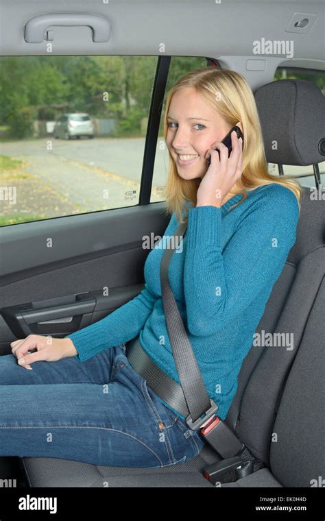 Junge Frau Angeschnallt Sitzen Auf Dem Rücksitz Eines Autos Mit Einem Mobiltelefon