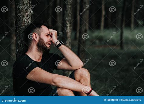 Young Depressed Man Sitting Alone In The Forest Stock Photo Image Of