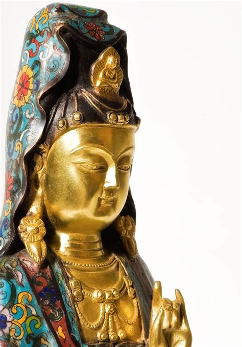 A Golden Buddha Statue Sitting In Front Of A White Background