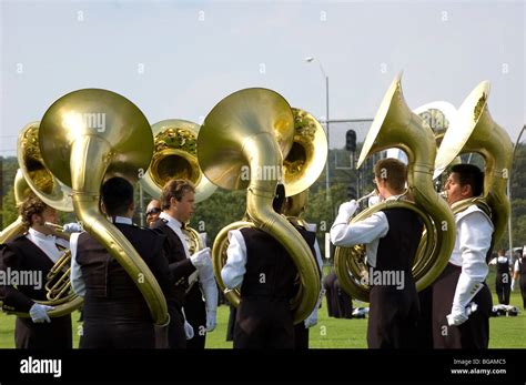 Tuba Players From A Marching Band Warming Up Before A Football Game