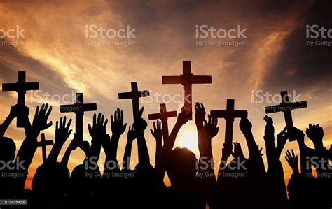 Group Of People Holding Cross And Praying In Back Lit Stock Photo