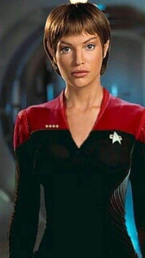 A Woman In A Star Trek Uniform Is Looking At The Camera