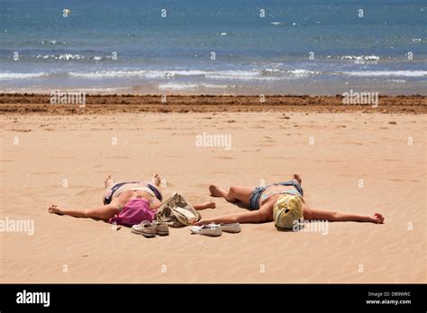 Two Women With Covered Heads Spread Eagle On Beach Sunbathing Stock Photo Royalty Free Image