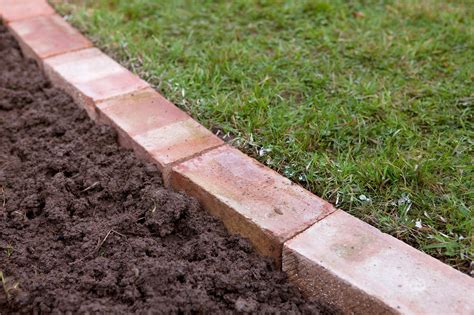 Dig a trench slightly wider and as long as the edging you next, build a temporary form to hold the wet concrete out of ordinary 2 x 4 lumber and wooden stakes. How to edge a lawn with bricks | Garden lawn edging, Brick ...