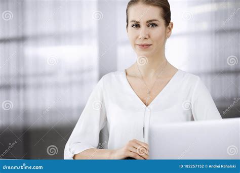 Businesswoman Sitting And Looking At Camera In Office Business