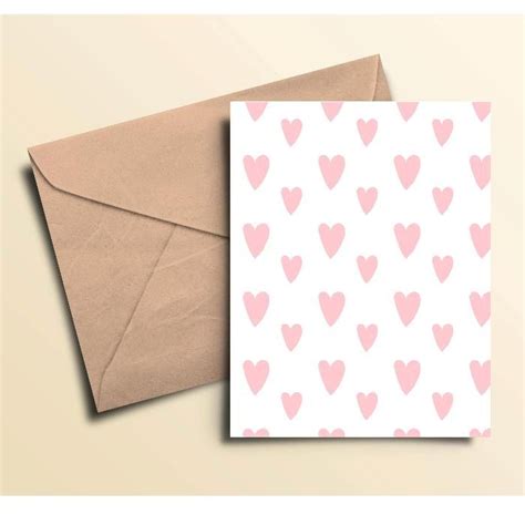 Two Cards With Pink Hearts On Them One Is Folded And The Other Has A