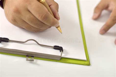 Man Writing On Blank Paper On Clipboard Stock Photo