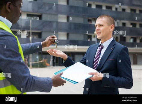 Engineer Giving Keys To New Apartment To Man Stock Photo Alamy
