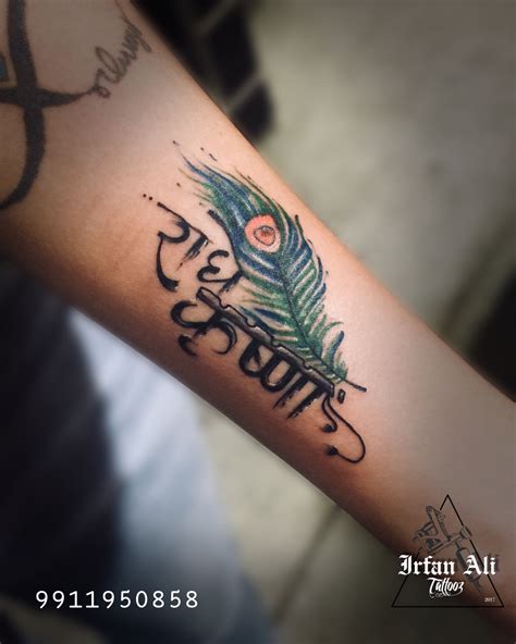 A Person With A Tattoo On Their Arm That Has A Feather And The Words