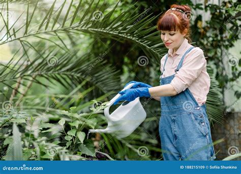 Smiling Young Female Gardener Watering The Flowers Happy Florist