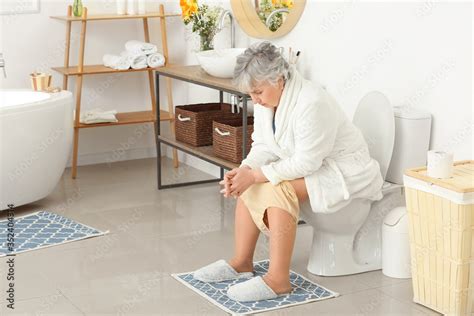 Elderly Woman With Hemorrhoids Sitting On Toilet Bowl In Bathroom Stock Photo Adobe Stock