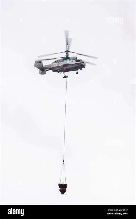 A Fire Helicopter Carries A Container Of Water To Extinguish A Fire In