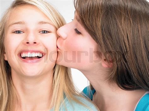 sisters cheek kissing stock image colourbox