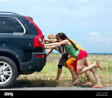 Three Girls Push The Broken Car Stock Photo Alamy