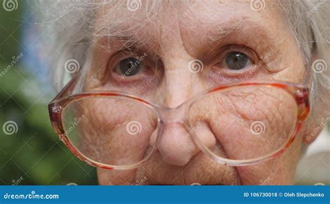old woman in eyeglasses turning her head and looking into camera granny wearing eyeglasses