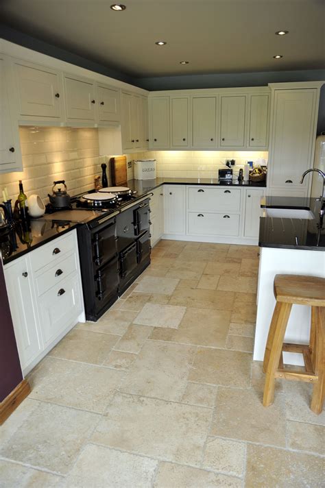 Countertop choices for white kitchen cabinetry. A modern kitchen design with white cabinets and travertine ...