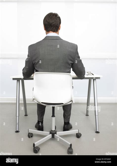 Rearview Of A Business Man Sitting At His Desk Stock Photo Alamy