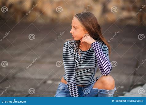 Young Teenage Poses To Photographer Blonde Girl In Jeans And Blouse