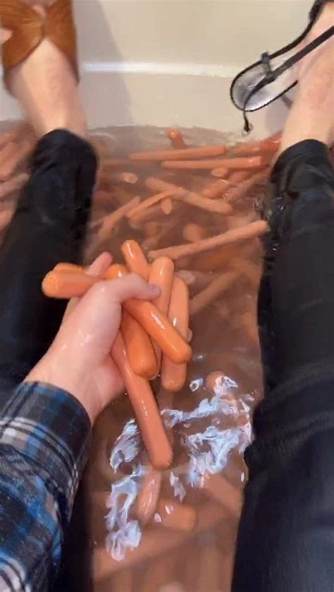 A Person Is Holding Carrots In The Water While Another Person Holds