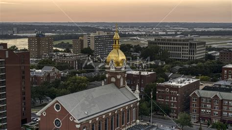 A Brick Cathedral With Golden Steeple At Sunset In Downtown Kansas City