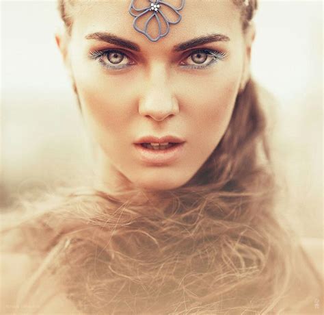 A Woman With Long Hair And Blue Eyes Has A Flower On Her Forehead