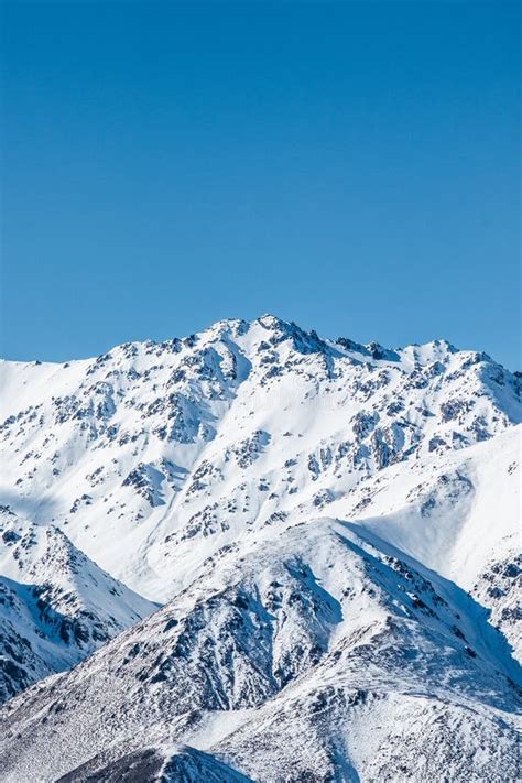 Mountain Landscape Snow Capped Peaks On Blue Sky Background Winter