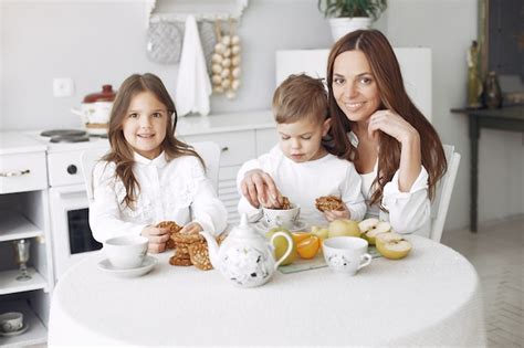 Madre Con Hijos Sentados En La Cocina Y Comer Foto Gratis