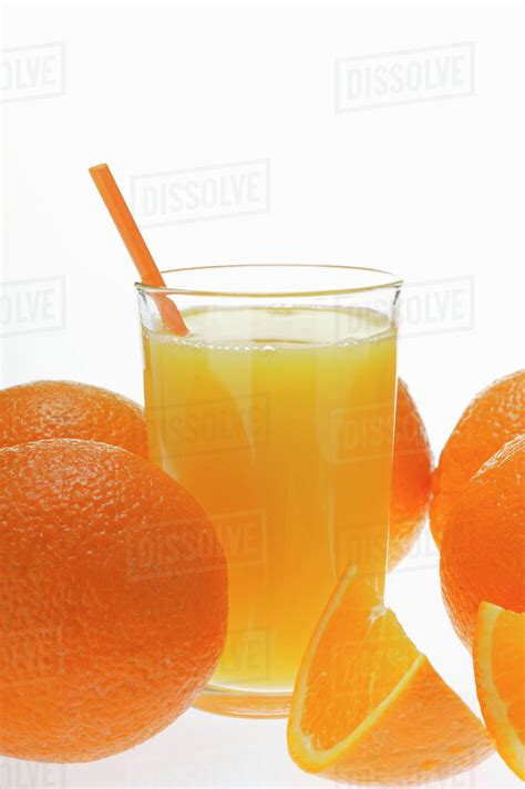 Orange Juice In Glass With Straw Among Oranges Stock Photo Dissolve