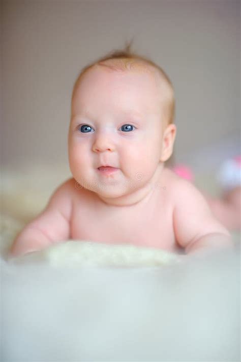 The Newborn Baby With Big Beautiful Eyes Lies On A Sofa Stock Photo