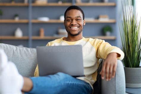 Positive Black Man Chilling On Sofa Using Laptop Stock Image Image