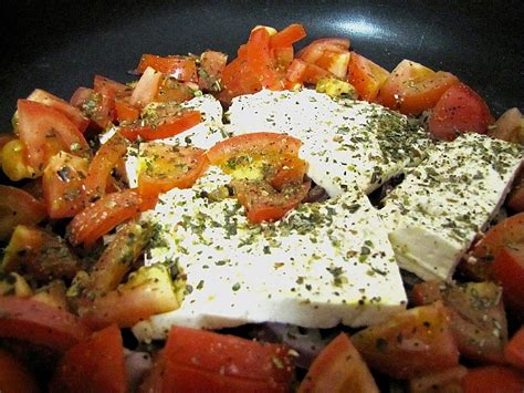 Feta Schafskäse auf Tomaten und Zwiebeln in der Pfanne gebacken von
