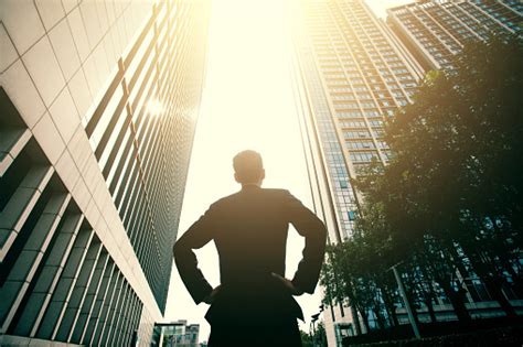 Businessman Standing Between City Buildings Stock Photo Download