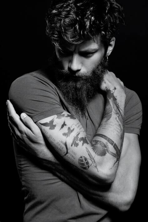 A Bearded Man With Tattoos On His Arms