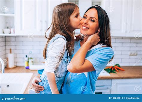 Happy Motherand X27s Day Little Daughter Kissing And Hugging Her Smiling Mom In Light Modern