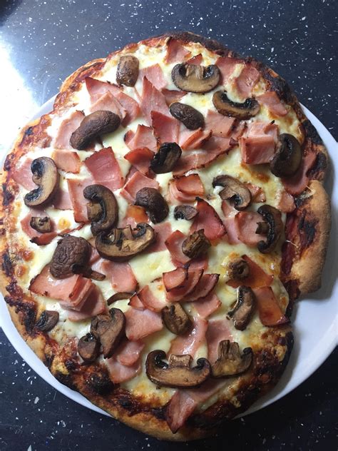Two Pizzas With Mushrooms Ham And Cheese On A White Plate Sitting On A